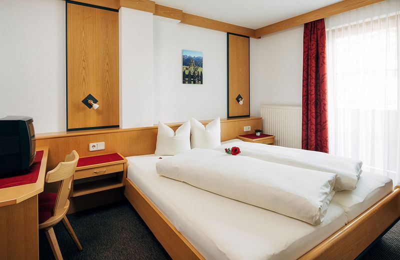 Schlafzimmer mit Doppelbett und Holzmöbeln